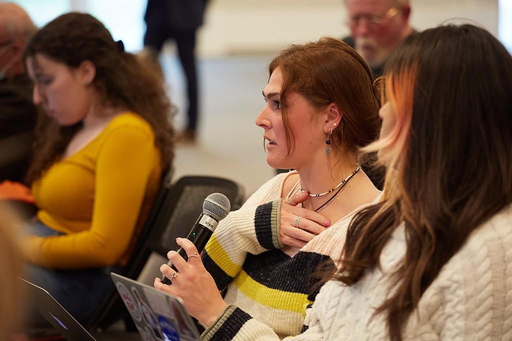 A student asks a question at a lecture